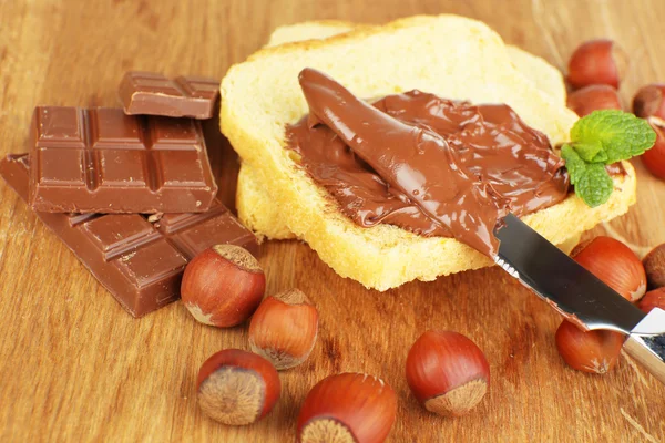 甘いチョコレートのヘーゼル ナッツ スプレッド木製の背景を持つパンします。 — ストック写真