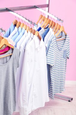 Askı, pembe bir arka plan üzerinde farklı kıyafetler