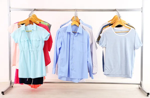 Different clothes on hangers, on gray background — Stock Photo, Image