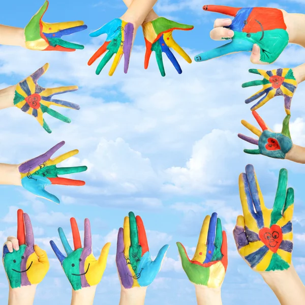 Painted hands with smile on sky background — Stock Photo, Image