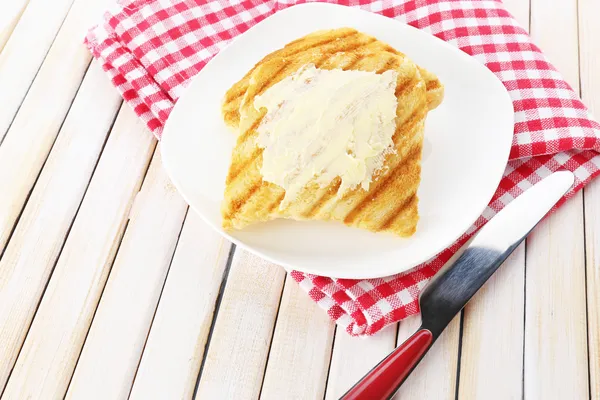 Grillat bröd med smör på träbord — Stockfoto