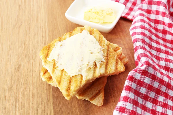 Grilled bread with butter on wooden table — Stock Photo, Image