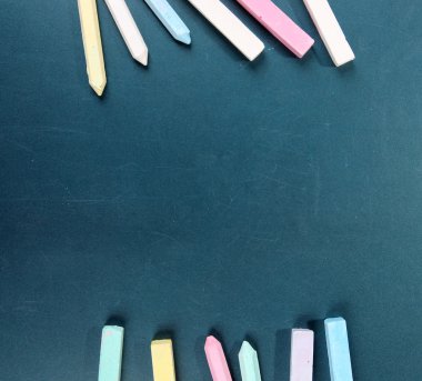 Colorful chalks on school desk clipart