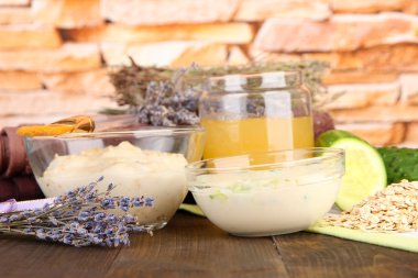 parlak arka plan üzerinde renkli ahşap masa üzerinde doğal maddeler ile ev yapımı yüz maskeleri