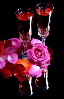 Pembe şarap gözlük, şişe ve siyah arka plan üzerine izole gül ile kompozisyon