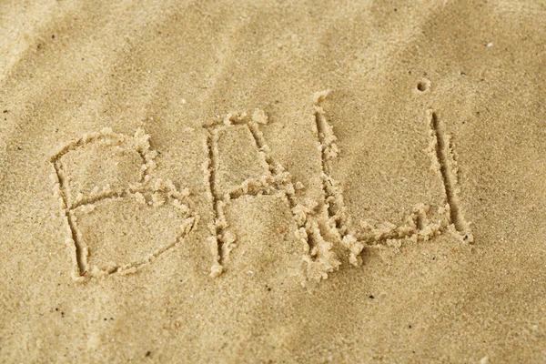 Inscription Bali on wet sand close-up background — Stock Photo, Image