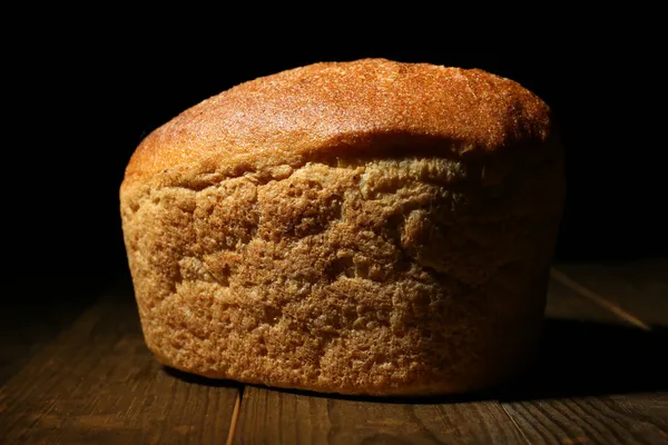 Bochenek chleba na ciemnym tle — Zdjęcie stockowe
