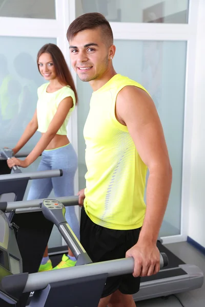 Chico y chica en cintas de correr en el gimnasio — Foto de Stock