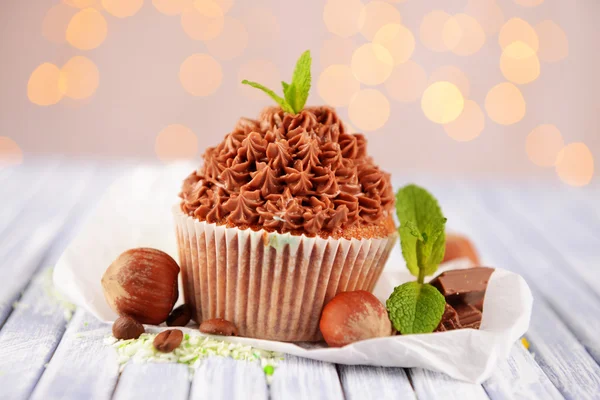Välsmakande cupcake med smörkräm, på trä färgtabell på ljus bakgrund — Stockfoto