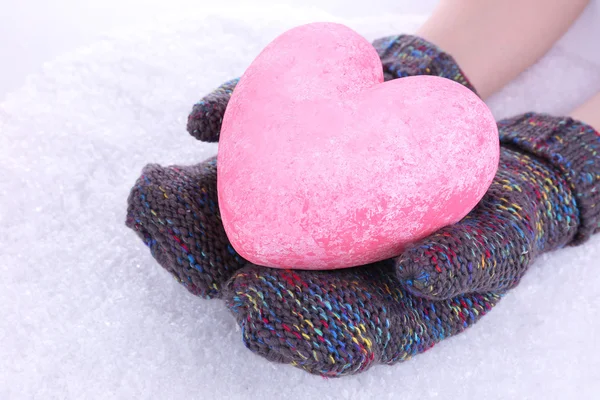 Mani femminili in guanti con cuore su sfondo neve — Foto Stock