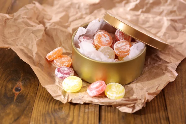 Sweet candies in metal can, on wooden background — Stock Photo, Image