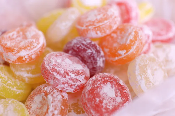 Dulces caramelos multicolores sobre papel, primer plano — Foto de Stock