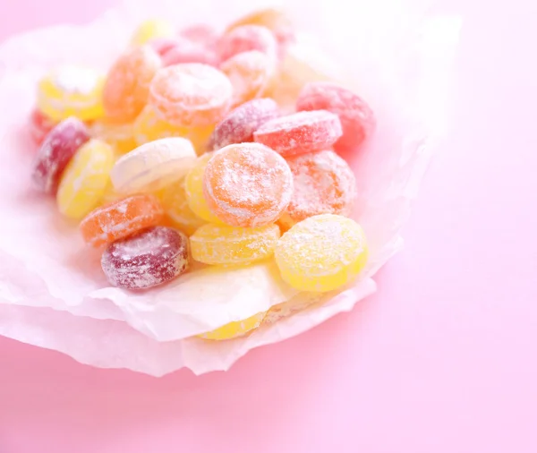 Sweet multicolor candies on paper, on color background — Stock Photo, Image