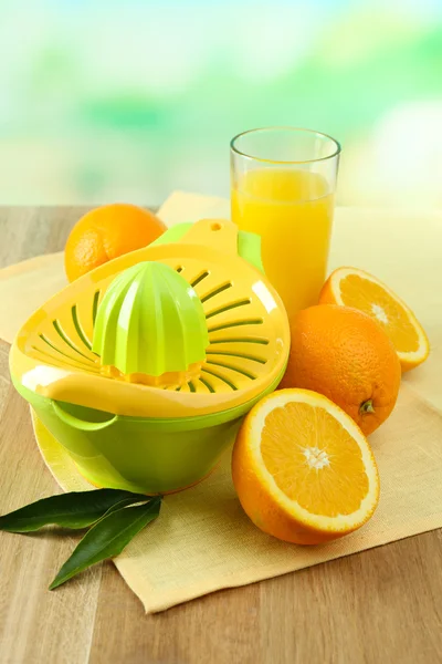 Citrus press and oranges on table on blue background — Stock Photo, Image