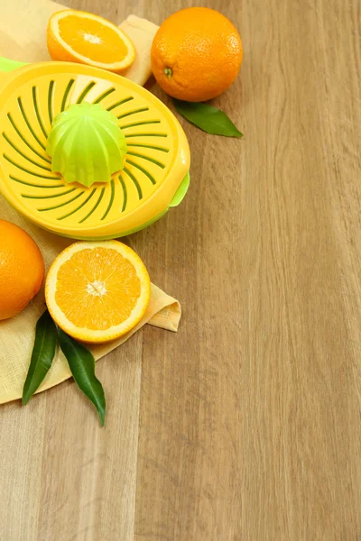 Citrus press and oranges on wooden background — Stock Photo, Image