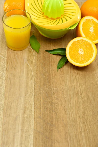 Presse agrumes et oranges sur fond bois — Photo