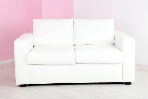 Bílá pohovka v pokoji na pozadí růžové zdi — Stock fotografie
