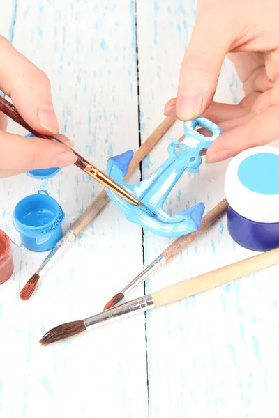 Hands paints on hand made ceramic anchor and art materials — Stock Photo, Image