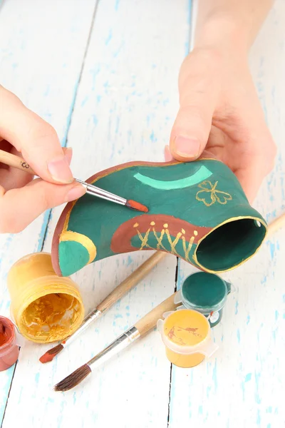 Hands paints on and made ceramic saint patricks day boot and art materials — Stock Photo, Image