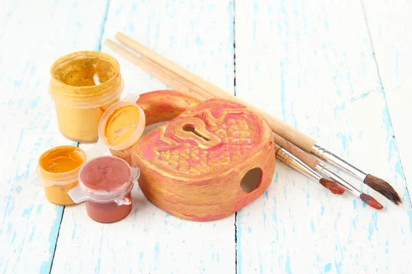 Hand made ceramic castle and color paints on wooden table — Stock Photo, Image