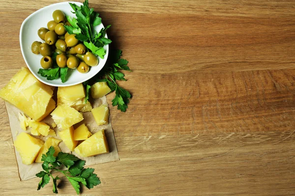 Parmesan, frische Kräuter und Oliven auf Holzgrund — Stockfoto