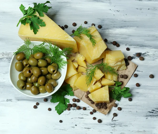 Parmigiano, erbe fresche e olive su fondo di legno — Foto Stock