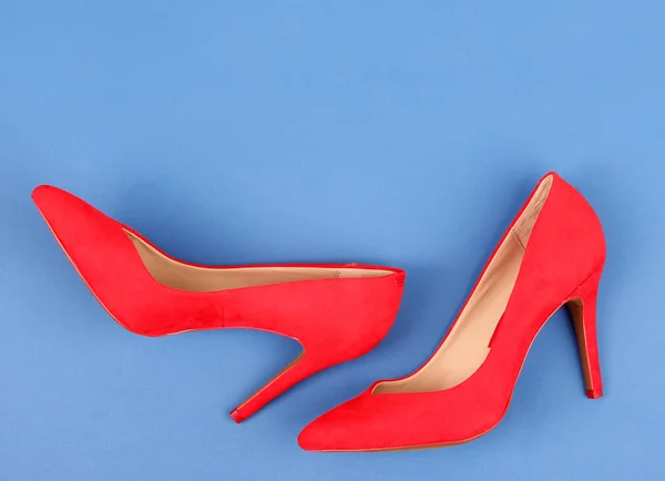 Beautiful red female shoes, on blue background — Stock Photo, Image