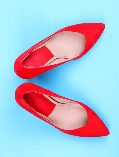 Hermosos zapatos femeninos rojos, sobre fondo azul —  Fotos de Stock