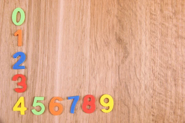 Барвисті цифри на дерев'яному фоні — стокове фото
