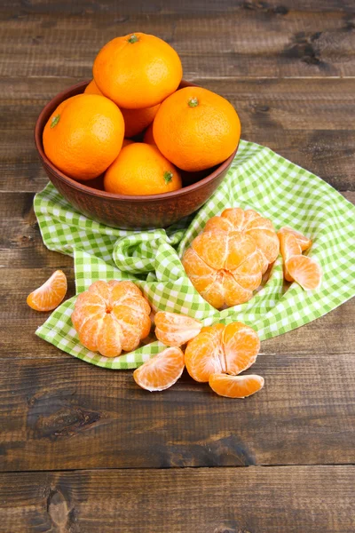 Reife süße Mandarinen mit Gewürzen in Schüssel, auf Serviette, auf Holzgrund — Stockfoto