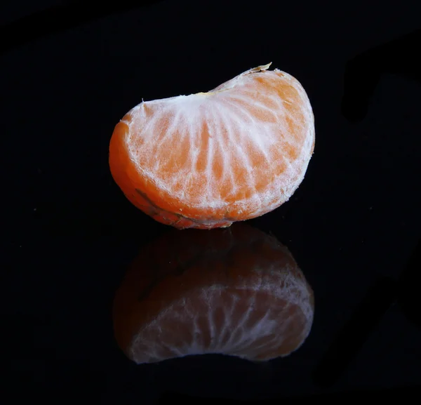 Dojrzałe słodkie kawałek mandarynki, na czarnym tle — Zdjęcie stockowe