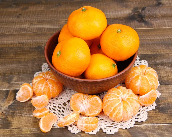 Ripe sweet tangerines with spices in bowl, on napkin, on wooden background — Stock Photo, Image