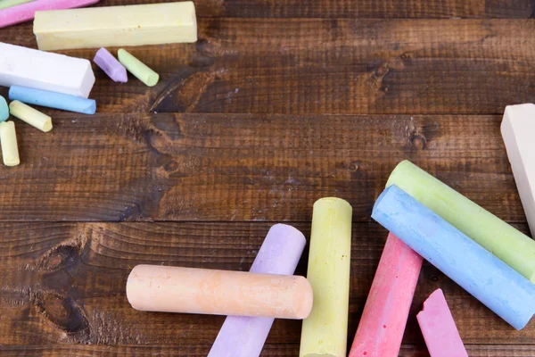 Chalks in variety of colors, on wooden background — Stock Photo, Image