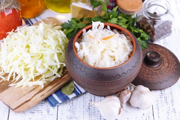 Composition with fresh and marinated cabbage (sauerkraut), spices, on wooden table background — Stock Photo, Image