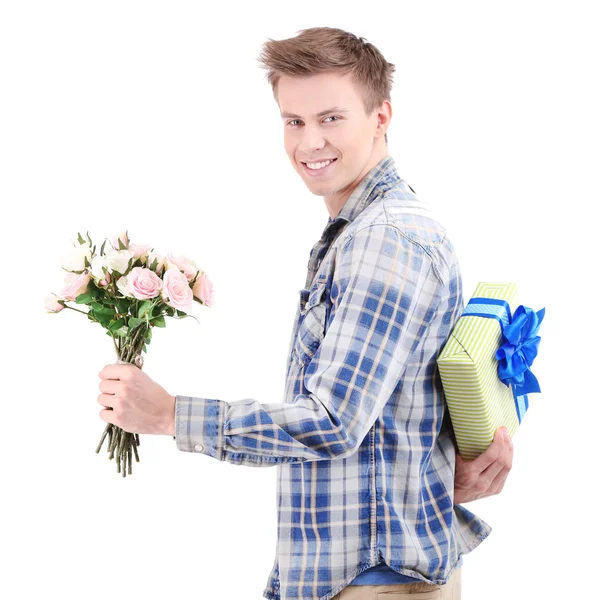 Jovem bonito com flores e presente, isolado em branco — Fotografia de Stock