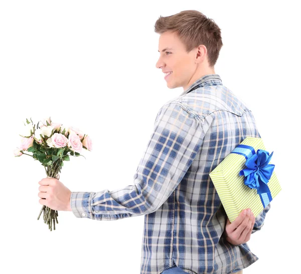 Jovem bonito com flores e presente, isolado em branco — Fotografia de Stock