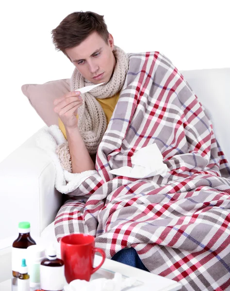 Le gars enveloppé dans un plaid assis sur un canapé est malade — Photo