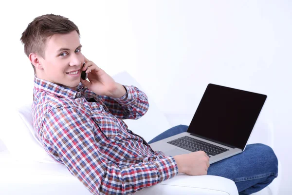 Mann telefoniert auf Sofa auf weißem Hintergrund — Stockfoto