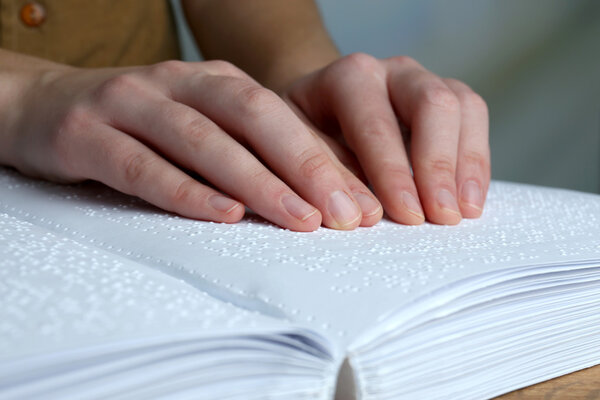 Blind woman read book written in Braille