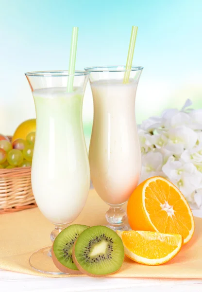 Milkshake med frukter på tabellen på ljusblå bakgrund — Stockfoto