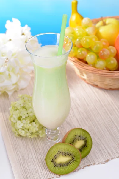 Batido de leite na mesa no fundo azul claro — Fotografia de Stock