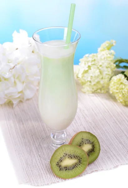 Batido de leite na mesa no fundo azul claro — Fotografia de Stock