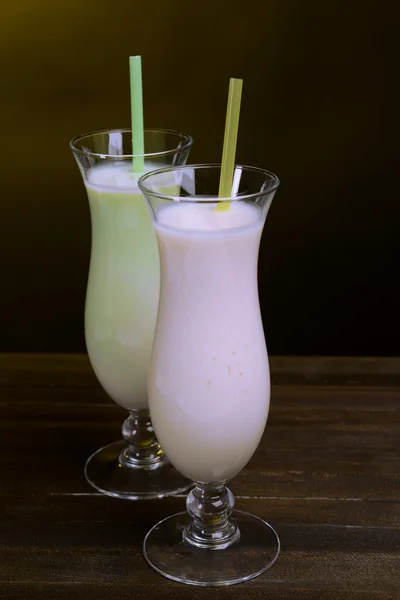 Milk shakes on table on dark yellow background — Stock Photo, Image