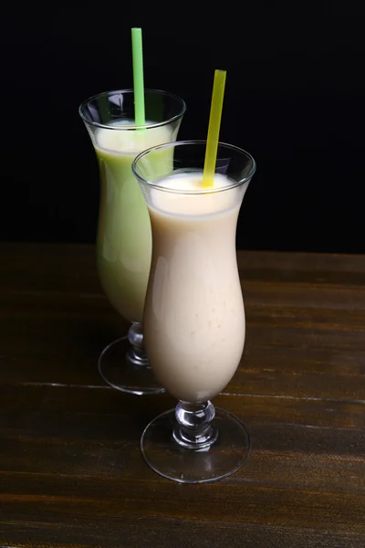 Milk shakes on table on black background — Stock Photo, Image