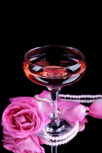 Sammansättning med rosa gnistra vin i glas och rose isolerade på svart — Stockfoto