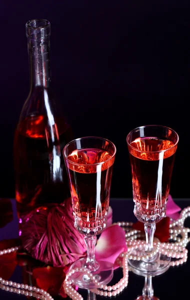 Skład wina różowe okulary, butelki i róż na tle ciemnego koloru — Zdjęcie stockowe