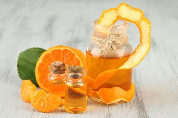 Tangerine essential oil and tangerines on wooden table — Stock Photo, Image