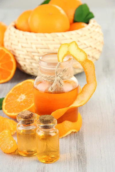 Óleo essencial de tangerina e tangerinas na mesa de madeira — Fotografia de Stock