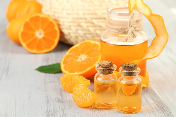 Óleo essencial de tangerina e tangerinas na mesa de madeira — Fotografia de Stock