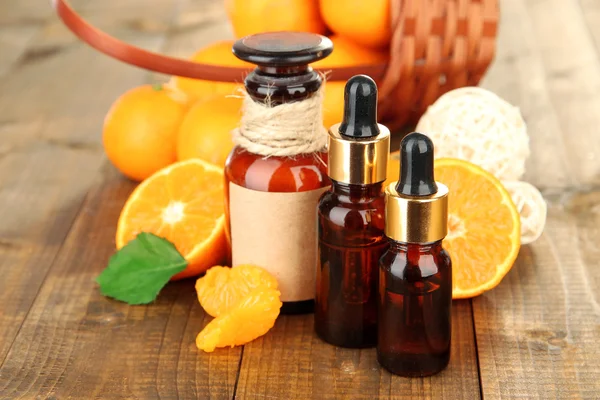 Tangerin eterisk olja och tangeriner på träbord — Stockfoto
